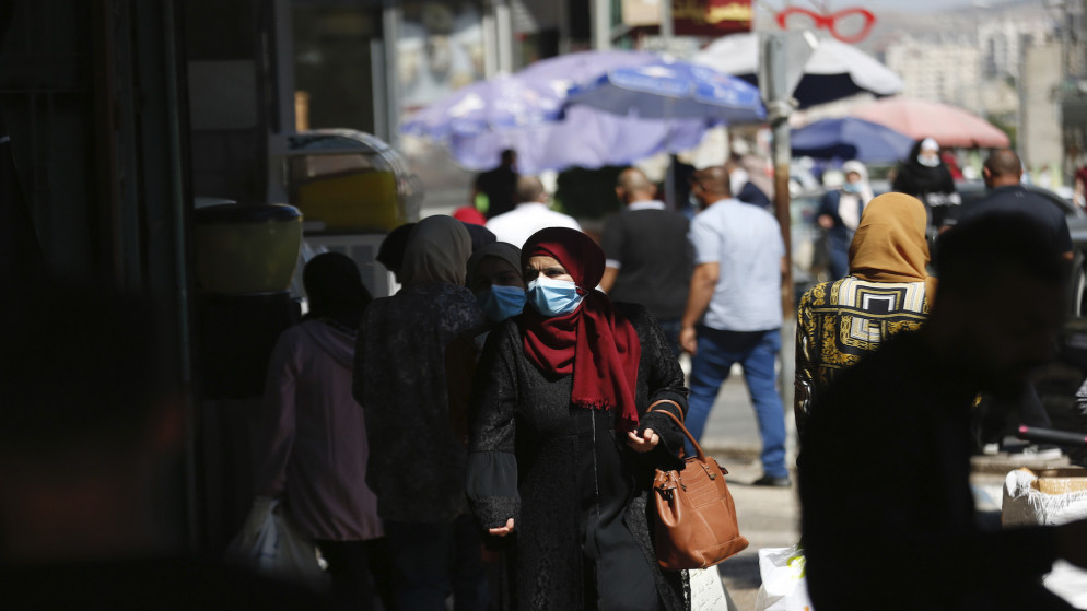 فلسطينييون يرتدون كمامات خلال تجولهم في مدينة نابلس في الضفة الغربية المحتلة. 2020/6/25. (أيمن نوباني/ وفا)