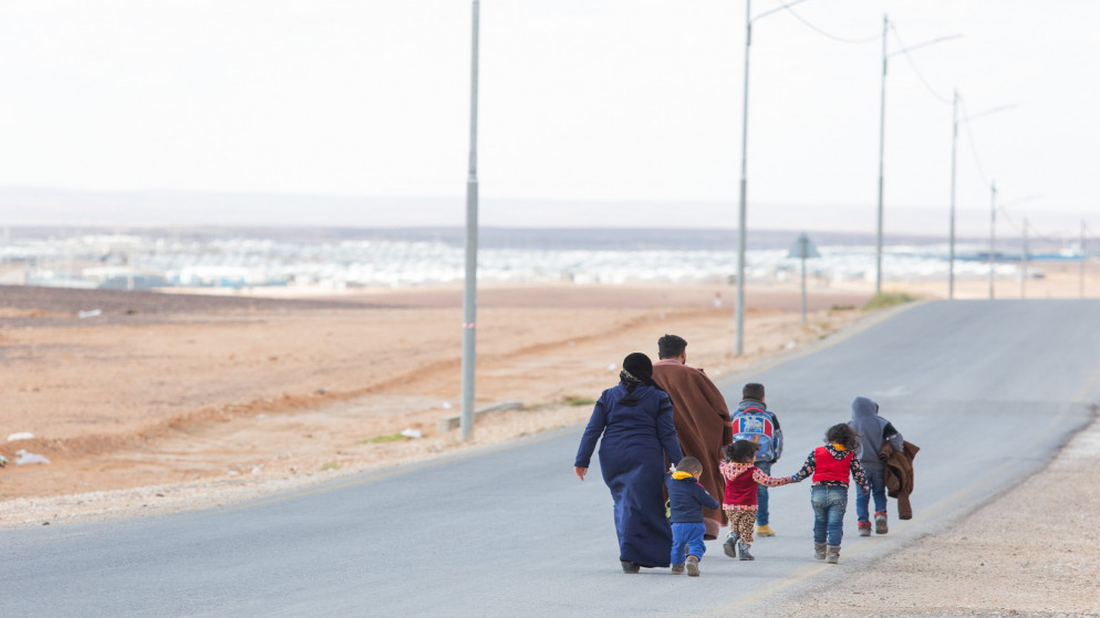 أسرة تسير في شارع رئيسي في مخيم للاجئين السوريين في الأردن. (مفوضية الأمم المتحدة لشؤون اللاجئين)