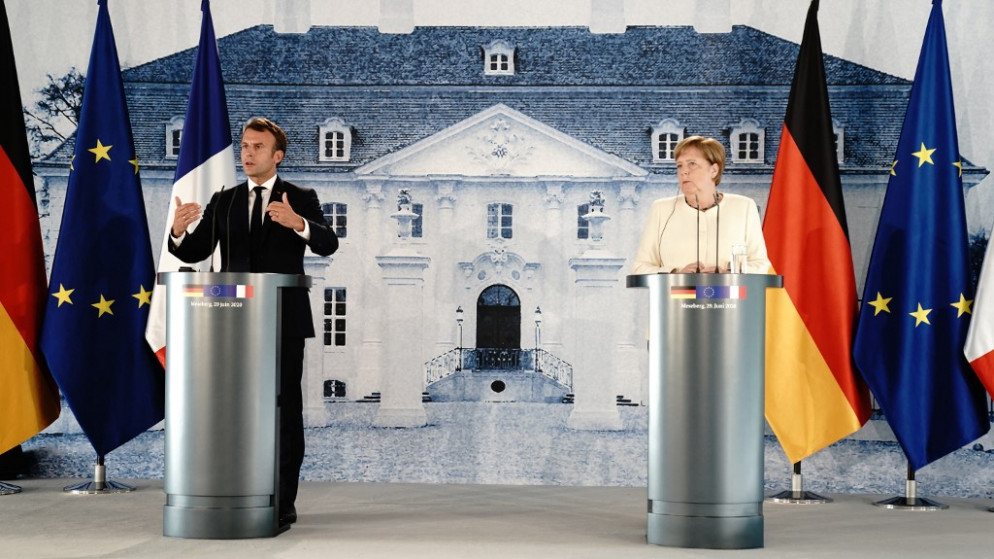 المستشارة الألمانية أنغيلا ميركل والرئيس الفرنسي إيمانويل ماكرون، يعقدان مؤتمرا صحفيا، في بيت الضيافة الحكومي الألماني في ميسبرغ، خارج برلين، 29 يونيو 2020. (أ ف ب)