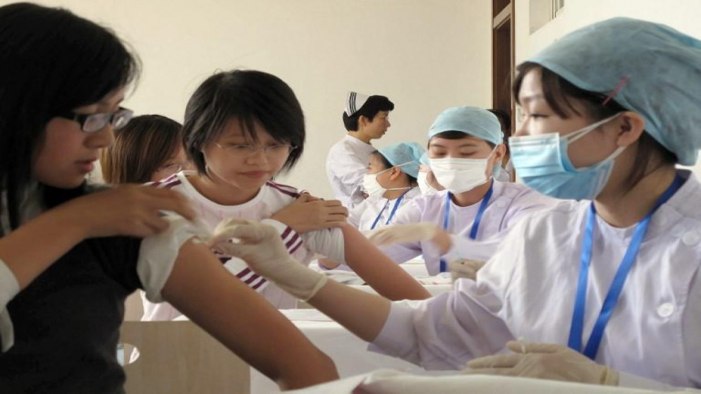 صورة أرشيفية لطاقم طبي يعطي لقاحات لطلاب ضد إنفلونزا الخنازير في بكين 22 سبتمبر 2009. أ ف ب
