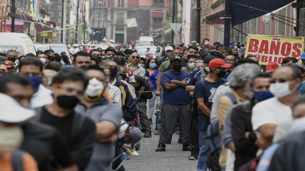 يصطف الناس في شارع ينتظرون المرور إلى وسط مدينة مكسيكو سيتي، 6 يوليو 2020. (أ ف ب)