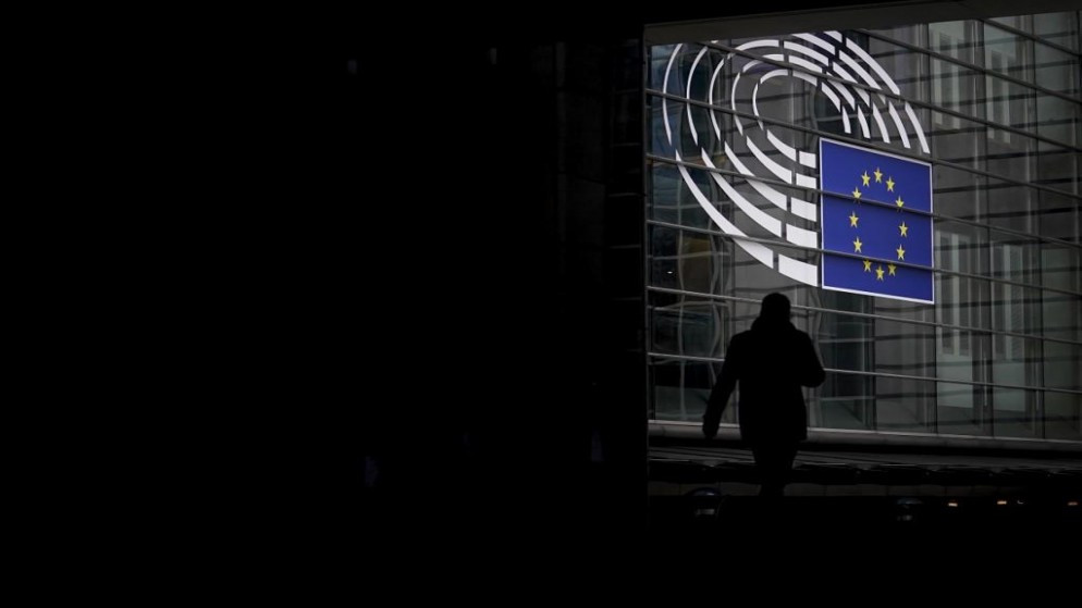 رجل يمر قرب البرلمان الأوروبي في بروكسل. (أ ف ب)