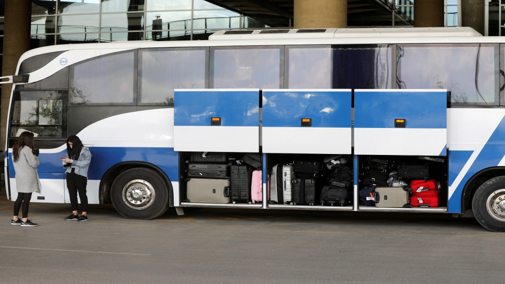 طلبة أردنيون أمام حافلات تنقلهم من مطار الملكة علياء الدولي بعد عودتهم إلى أماكن الحجر الصحي، 6 مايو/أيار 2020. (محمد حامد/ رويترز)