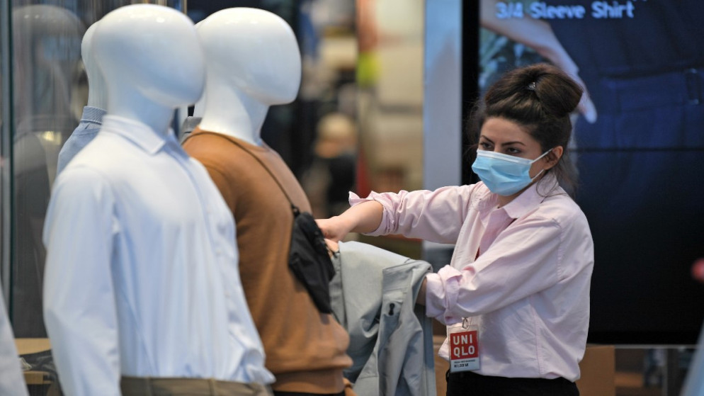 عاملة في متجر بيع ملابس ترتدي كمامات للوقاية من فيروس كورونا المستجد في شارع أكسفورد في لندن. 12/06/2020. (دانيال ليل اوليفاس/ أ ف ب)