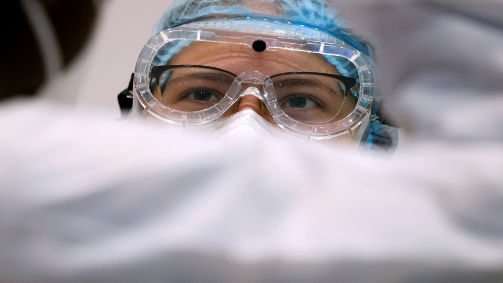 عاملة في القطاع الصحي تنتظر المسافرين لإجراء فحص الكشف عن فيروس كورونا المستجد في مطار شارل ديغول في فرنسا، 31 تموز/يوليو 2020. (أ ف ب)