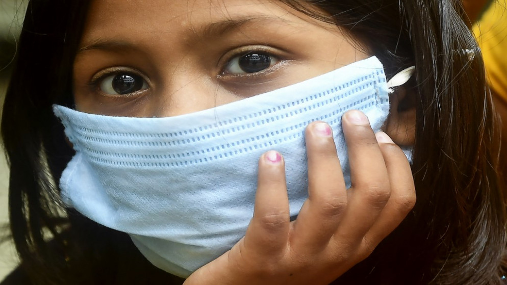 فتاة ترتدي كمامة طبية تنتظر دورها لإجراء فحص الكشف عن فيروس كورونا المستجد في كلكوتا في الهند، 28 نموز/يوليو 2020. (أ ف ب)