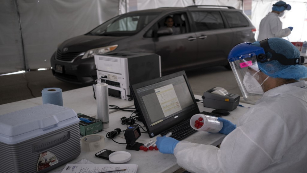 يسجل عامل المختبر عينات في مركز اختبار COVID-19، في موقف للسيارات، متعدد الأغراض في تيخوانا في ولاية باجا كاليفورنيا، المكسيك، 21 يوليو 2020. (أ ف ب)