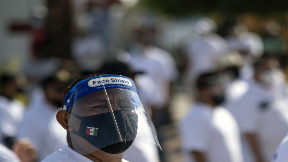 رجل يرتدي قناع وجه خلال مسيرة لعمال الحانات للمطالبة بإعادة فتح أعمالهم بعد أكثر من أربعة أشهر من إغلاقها بسبب وباء فيروس كورونا الجديد.المكسيك.(غييرمو أرياس / أ ف ب)
