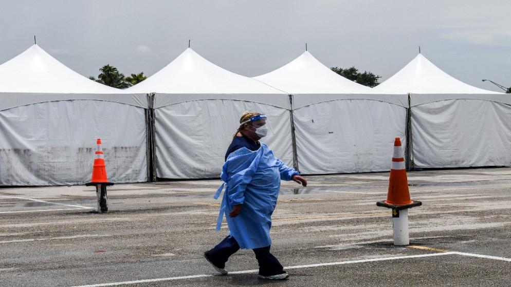 أحد أفراد الطاقم الطبي يرتدي معدات الحماية الشخصية بما في ذلك أقنعة الوجه والدرع بالقرب من موقع اختبار في حدائق ميامي . 5 أغسطس 2020.(أ ف ب)