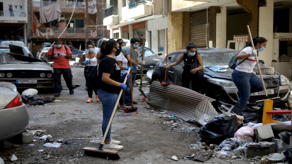 متطوعون وأعضاء من المجتمع المدني ينظفون الأنقاض في أحد شوارع حي مار ميخايل بيروت المتضرر، 6 أغسطس 2020، في أعقاب انفجار ضخم في العاصمة اللبنانية. (أ ف ب)