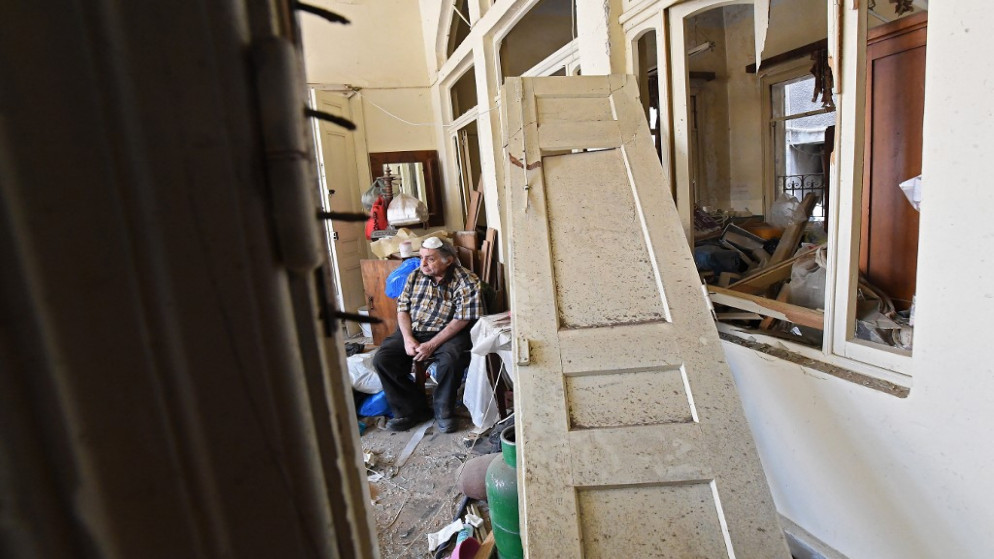 رجل يجلس داخل منزله المدمر في العاصمة اللبنانية بيروت في 6 آب / أغسطس 2020 ، بعد يومين من انفجار هائل هز العاصمة اللبنانية.(أ ف ب)