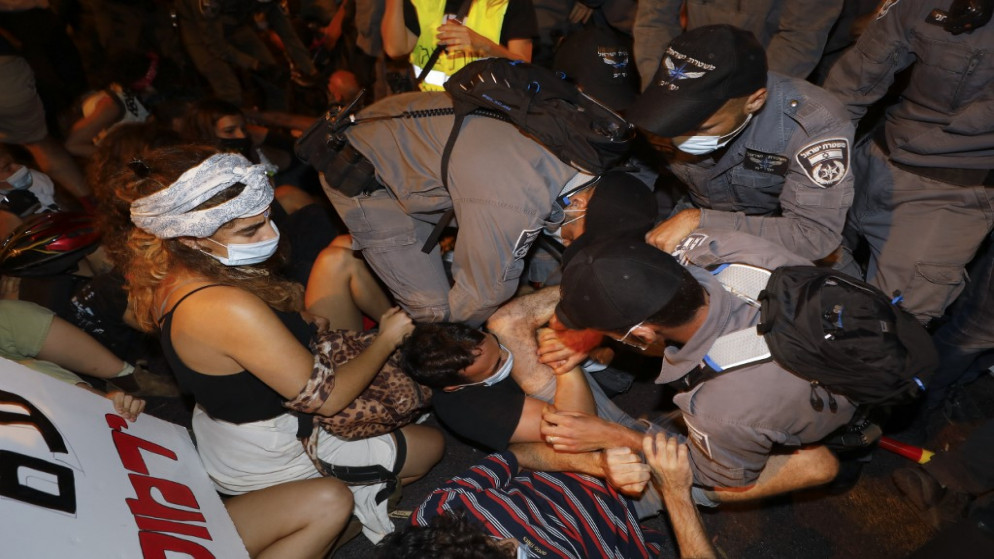 رجال الشرطة الإسرائيلية يزيلون المتظاهرين من الشارع خلال مظاهرة شارك فيها الآلاف ضد الحكومة الإسرائيلية بالقرب من مقر نتنياهو، 2 أغسطس 2020. (أ ف ب)