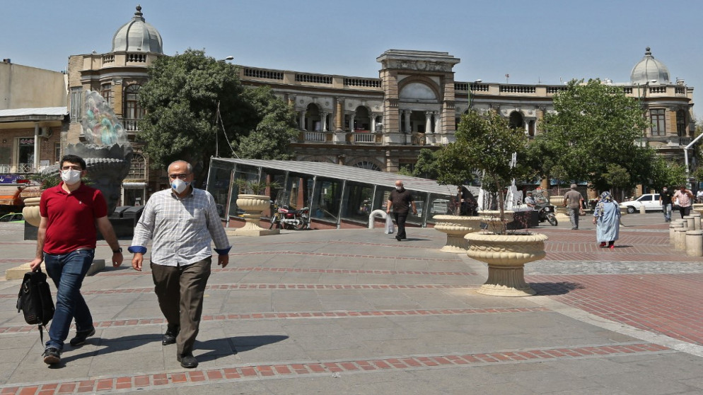 إيرانيون يرتدون أقنعة واقية بسبب جائحة فيروس كورونا يسيرون في ساحة حسن آباد في العاصمة طهران . 4 أغسطس ، 2020. (أتا كيناري / أ ف ب)