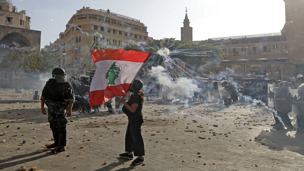 تظاهر لبناني يلوح بالعلم الوطني خلال اشتباكات مع قوات الأمن في وسط بيروت في 8 آب / أغسطس 2020 .(أ ف ب)
