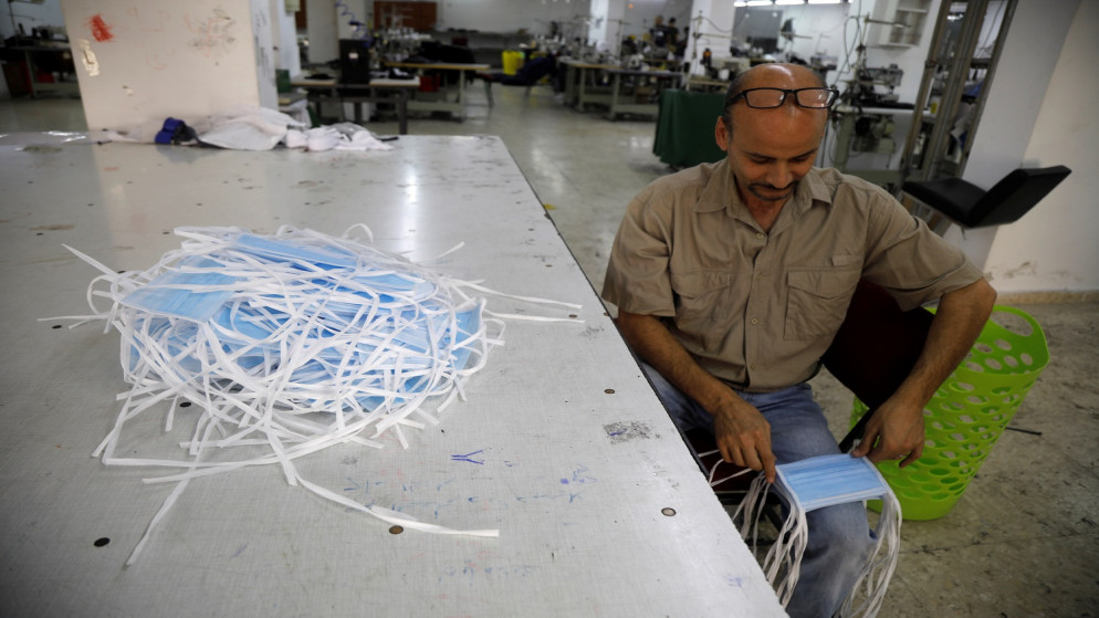 عامل فلسطيني في مصنع نسيج لتصنيع الكمامات في نابلس بالضفة الغربية المحتلة . 22 يوليو ، 2020. (رويترز / رنين صوافطة).