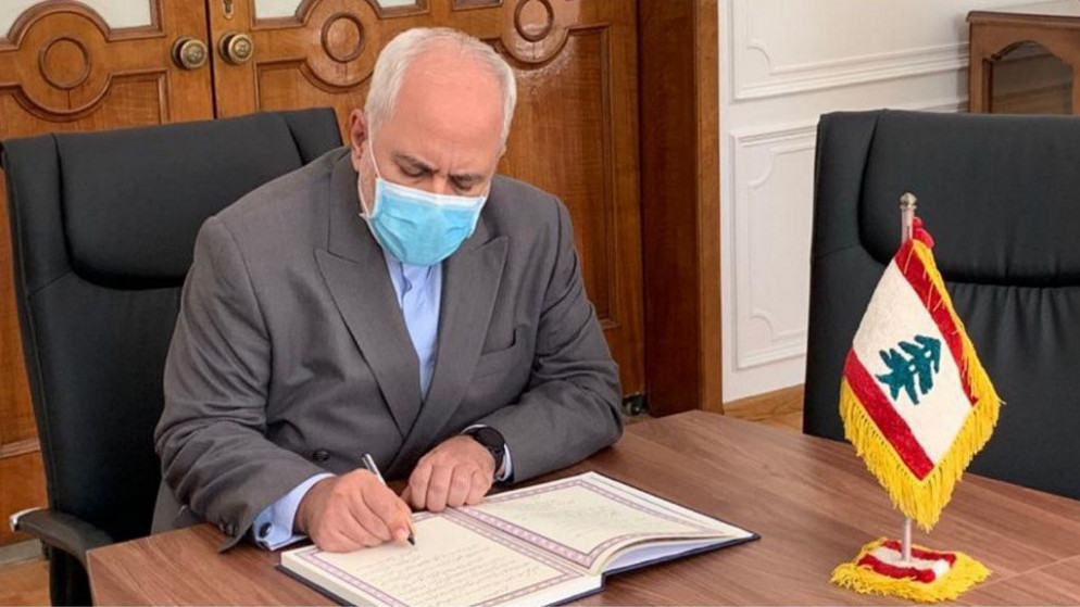 وزير الخارجية الإيراني محمد جواد ظريف خلال كتابته في سجل التعازي لضحايا الانفجار في مرفأ بيروت  في مقر السفارة اللبنانية في العاصمة الإيرانية طهران. (أ ف ب)
