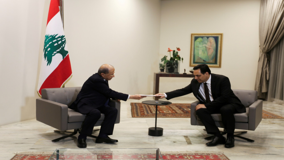 الرئيس اللبناني ميشال عون (يسار) يتسلم استقالة حكومة رئيس الوزراء حسان دياب. (رويترز)