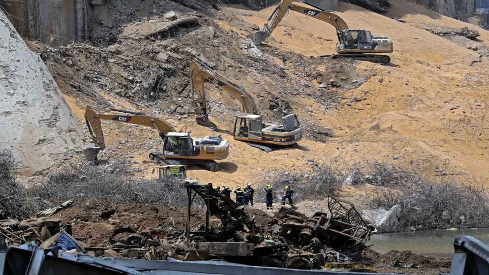 عمال الإنقاذ يستخدمون الحفارات لإزالة الأنقاض في موقع صوامع الحبوب المتضررة في ميناء بيروت. 12 أغسطس 2020. (أ ف ب)