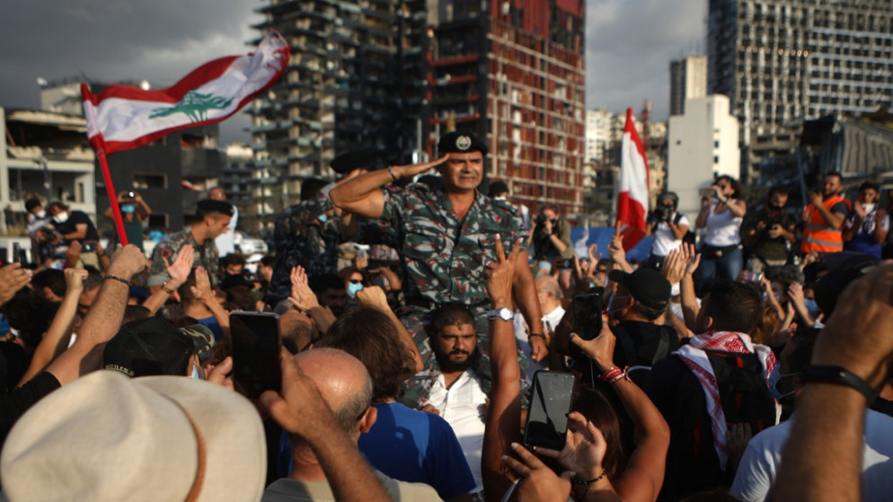 حشد يهتف لأعضاء الدفاع المدني اللبناني، خلال مراسم لإحياء ذكرى ضحايا انفجار مرفأ بيروت مقابل ميناء العاصمة، 11 أغسطس 2020. (أ ف ب)