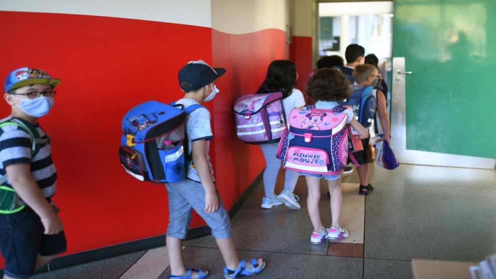 طلاب يرتدون أقنعة الوجه يدخلون الفصل الدراسي في مدرسة بتري الابتدائية في دورتموند  غرب ألمانيا. 12 أغسطس 2020.(رويترز)