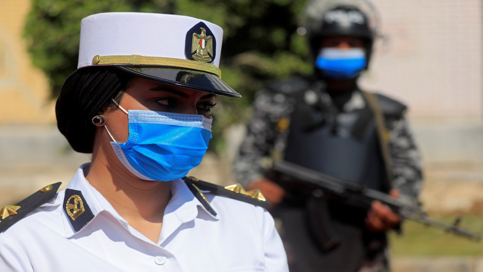 ضباط أمن يرتدون أقنعة الوجه يقفون في حراسة أمام مركز اقتراع خلال اليوم الثاني من انتخابات مجلس الشيوخ في القاهرة، 12 أغسطس 2020. (رويترز)
