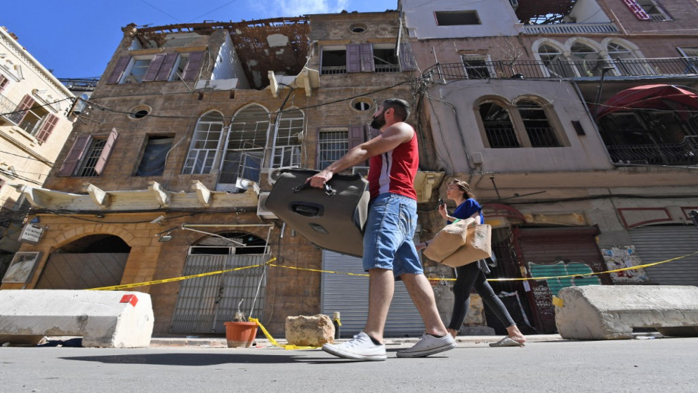 سكان حي الجميزة في بيروت، يحملون أمتعتهم أثناء إخلاء منازلهم المتضررة، إثر انفجار كارثي ضرب أجزاء كبيرة من العاصمة اللبنانية، 17 آب/ أغسطس 2020. (أ ف ب)