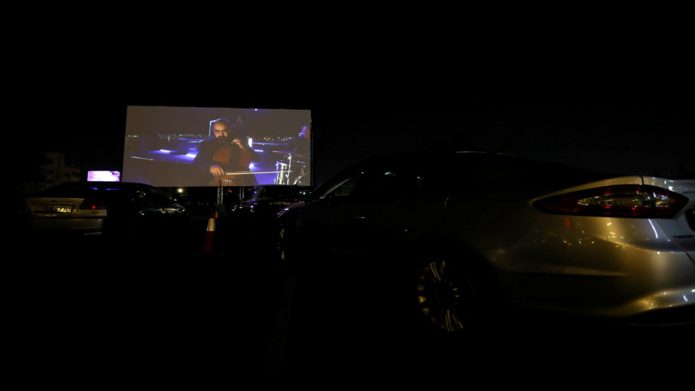 أشخاص يجلسون في سياراتهم خلال الافتتاح الرسمي لمهرجان عمان السينمائي الدولي في أول سينما  أثناء تفشي مرض فيروس كورونا (COVID-19). الأردن . 23 أغسطس  2020. (رويترز / محمد حامد)