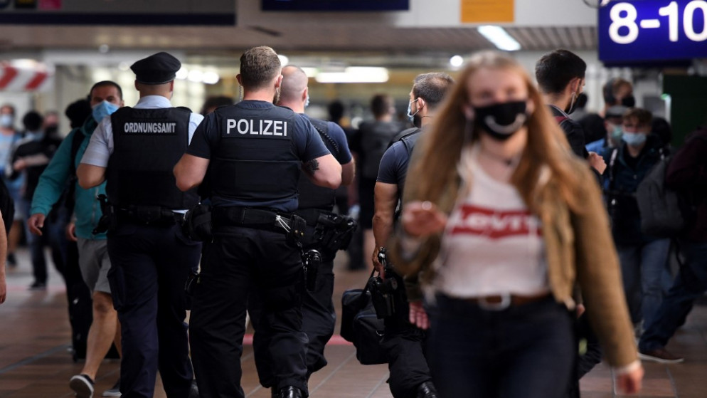 يقوم موظفو مكتب النظام العام، بإجراء عمليات التفتيش لضمان ارتداء الكمامة، وسط جائحة كورونا، محطة السكك الحديدية الرئيسية في دورتموند، غرب ألمانيا، 24 أغسطس 2020. (أ ف ب)