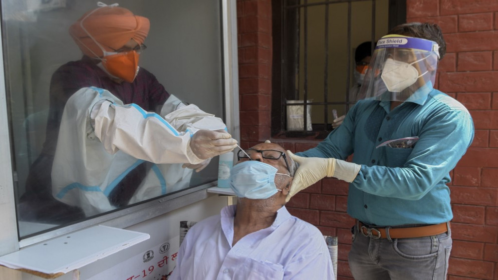 يجمع مسؤولو الصحة في الهند، مسحة أنفية من رجل لاختبار فيروس كورونا COVID-19، في مستشفى مدني في أمريتسار، 24 أغسطس 2020. (أ ف ب)
