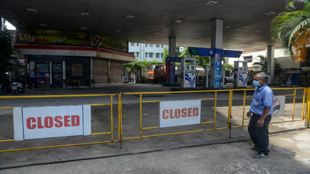 موظف يقف بالقرب من محطة الوقود مغلقة خلال فترة إغلاق فرضتها الهند لمدة يوم كامل كإجراء وقائي لوقف ارتفاع حالات الإصابة بفيروس كورونا. 27/08/2020. (أ ف ب)
