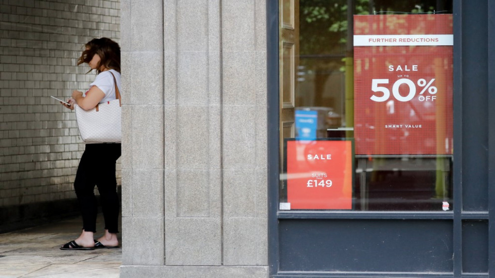 امرأة تقف بجوار متجر مغلق في مدينة لندن خلال فترة ركود اقتصادي في المملكة المتحدة جراء فيروس كورونا المستجد. 21/08/2020. (تولجا أكمين / أ ف ب)