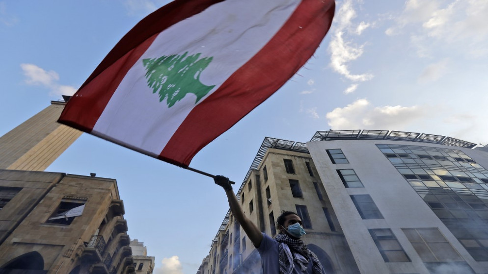 متظاهر لبناني يرفع العلم اللبناني في وسط العاصمة بيروت، 10 آب/أغسطس 2020. (جوزيف عيد/ أ ف ب)