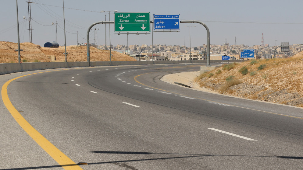 لافتات تظهر وجهات إلى محافظتي عمّان الزرقاء في شارع خالٍ من المركبات خلال حظر تجول شامل الجمعة. (القوات المسلّحة الأردنية)