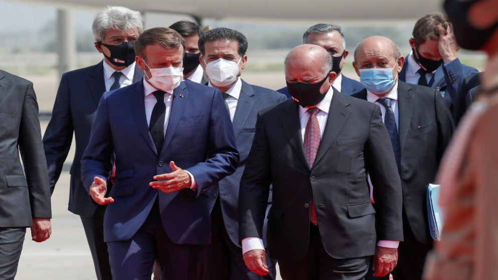 وزير الخارجية العراقي فؤاد حسين (يمين) خلال استقباله الرئيس الفرنسي إيمانويل ماكرون وأعضاء وفده في مطار بغداد. 02/09/2020. (جونزالو فوينتس / أ ف ب)