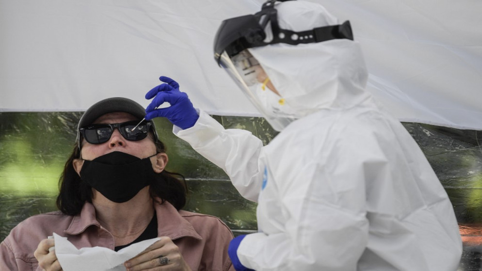 عاملة صحية تجمع عينة من امرأة لاختبار COVID-19، في مكسيكو سيتي، 15 يوليو 2020. (أ ف ب)