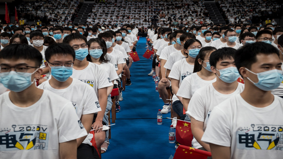 طلاب في جامعة هواتشونغ للعلوم والتكنولوجيا يتابعون حفل افتتاح حضره أكثر من 7000 طالب في صالة ألعاب رياضية في ووهان بمقاطعة هوبي في وسط الصين. 04/09/2020. (أ ف ب)