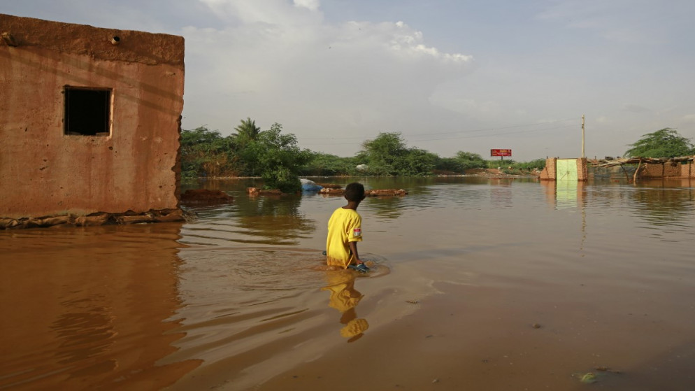 طفل سوداني يقف وسط شارع فائض بالمياه في مدينة أم درمان، 26 آب/أغسطس 2020. (أشرف شاذلي/ أ ف ب)