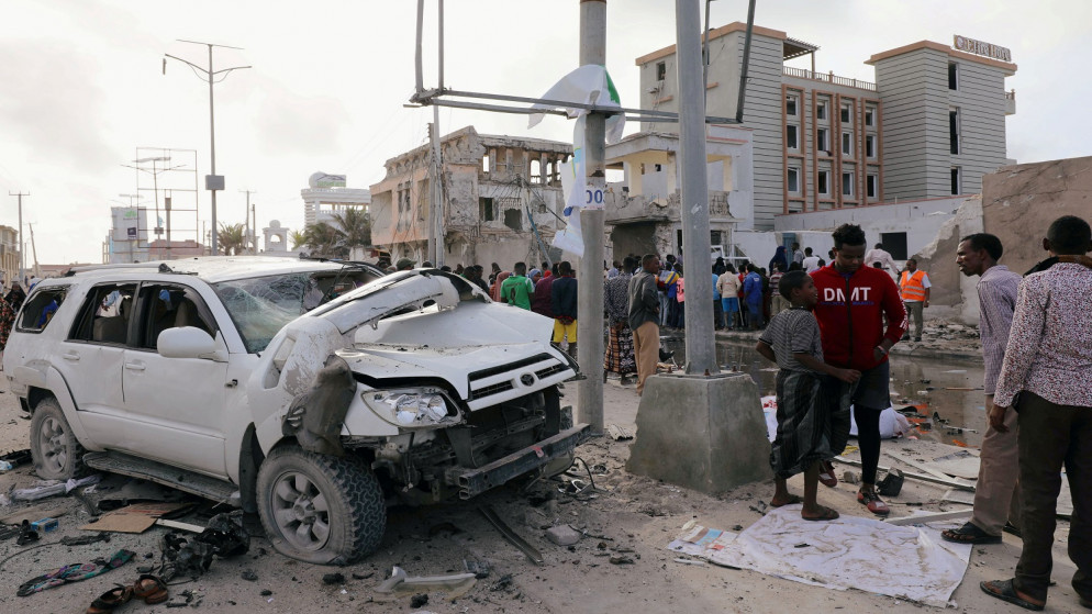 مدنيون بالقرب من حطام سيارة دمرت في موقع هجوم شنه مسلحون على فندق إليت في شاطئ ليدو في مقديشو ، الصومال ، 17 أغسطس ، 2020. (رويترز / فيصل عمر)