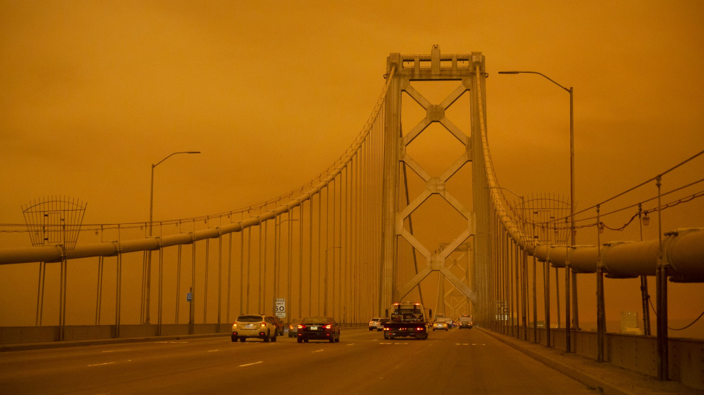 سيارات تسير على طول جسر خليج سان فرانسيسكو تحت سماء برتقالية ملأها الدخان في سان فرانسيسكو. 9 سبتمبر 2020. (أ ف ب)