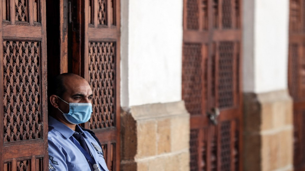 حارس أمن يرتدي كمامة للوقاية من الفيروس، يقف بجانب باب داخل المسجد الأزهر في وسط القاهرة، 28 آب/أغسطس 2020. (أ ف ب)