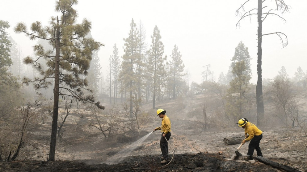 عناصر من أجهزة الطوارئ في كاليفورنيا الذين يكافحون حرائق هائلة أتت إلى الآن على نحو مليوني هكتار، أي ما يعادل تقريبا حجم ولاية نيوجيرزي. (أ ف ب)