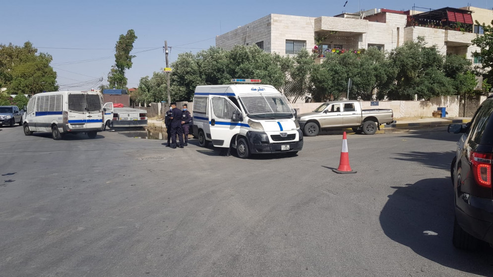 دوريتا شرطة تقفان أمام بنايات معزولة في عمّان بعد ظهور إصابات بالفيروس بين قاطنين فيها. (المملكة)