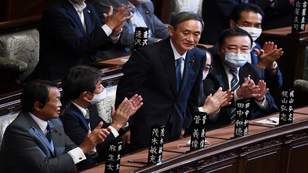 رئيس الوزراء الياباني الجديد يوشيهيدي سوغا (وسط) بعد انتخابه في البرلمان. 16/09/2020. (تشارلي تريباليو / أ ف ب)