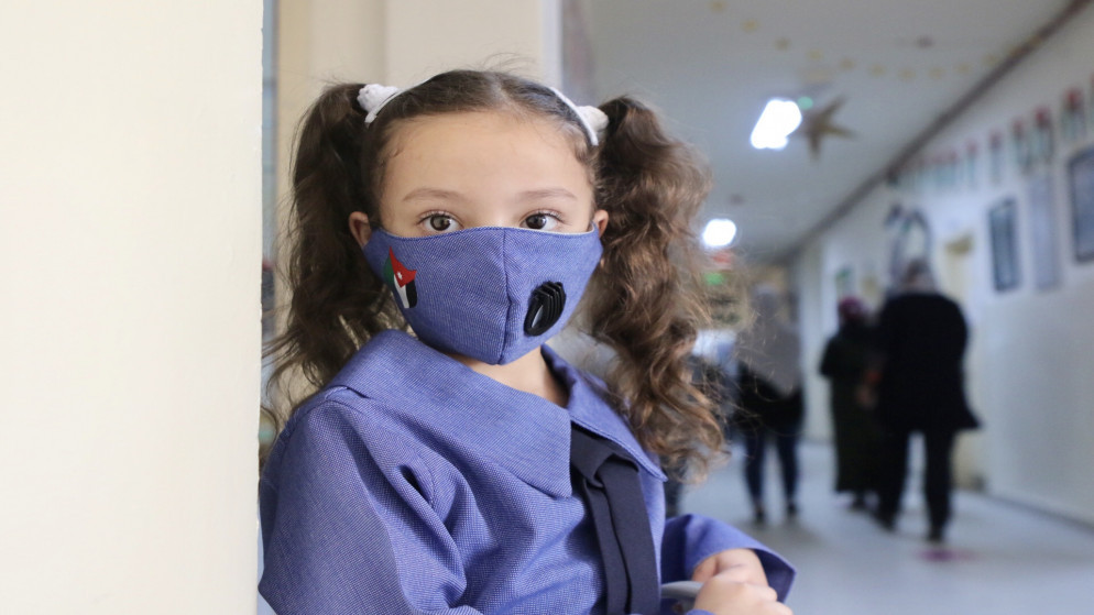 طالبة ترتدي كمامة زرقاء للوقاية من فيروس كورونا المستجد في أول يوم من العام الدراسي. (صلاح ملكاوي / المملكة)