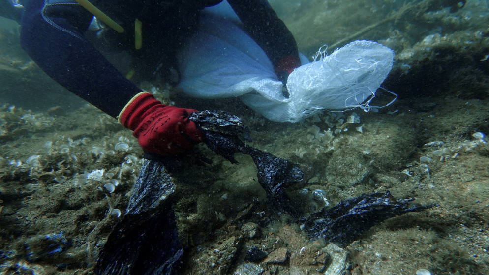 غواص متطوع يجمع النفايات البلاستيكية من قاع البحر قبالة جزيرة أندروس. اليونان . 20 يوليو ، 2019.(رويترز)