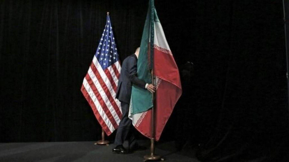 صورة أرشيفية لموظف يزيل العلم الإيراني بعد محادثات في مركز فيينا الدولي، 14 تموز/ يوليو 2015. أ ف ب