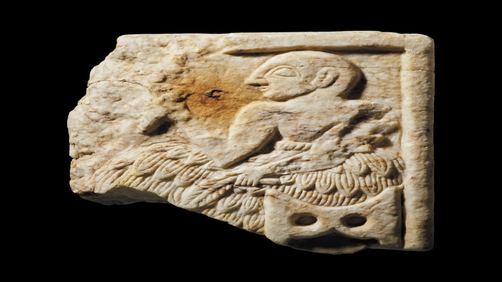 اللوح المنحوت في صخر كلسي يمثل شخصا يرتدي تنورة سومرية تقليدية هو في الواقع جزء من لوح جداري نذري من العام 2400 قبل الميلاد. (أ ف ب)