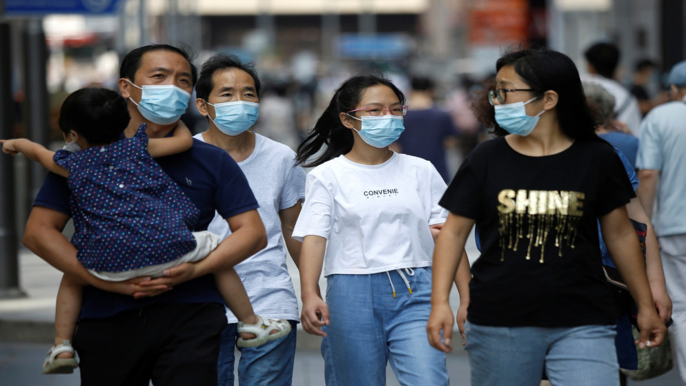 صينيون يرتدون كمامات واقية أثناء سيرهم في منطقة تسوق في بكين في الصين، 21/08/2020. (رويترز)