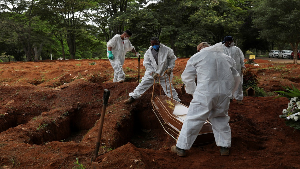 حفارو قبور يرتدون بدلات واقية يدفنون نعش رجل مات بسبب فيروس كورونا (كوفيد -19)، مقبرة فيلا فورموزا في ساو باولو ، البرازيل ، 25 كانون الأول/ ديسمبر 2020. (رويترز)