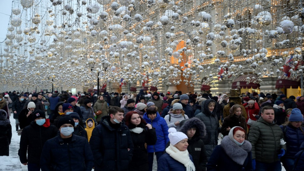 أشخاص، بعضهم يرتدي كمامات واقية، يسيرون في وسط موسكو، وسط جائحة كوفيد-19. 02/01/2021. (أ ف ب)